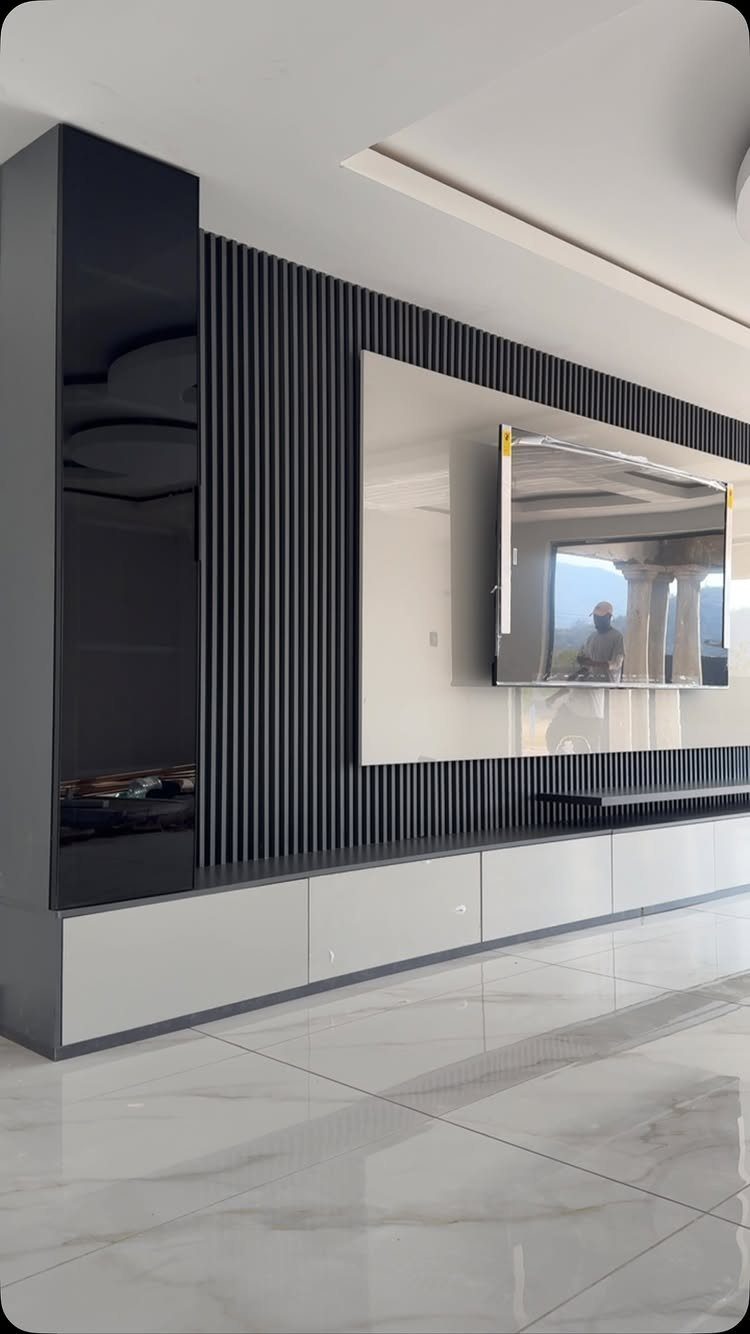 Modern asymmetrical TV unit with black slatted wall and white low-profile base cabinet.